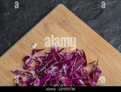 Fette di cavolo tritate sul tagliere di legno Foto Stock