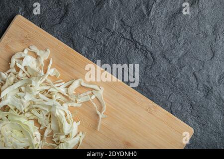 Cavolo bianco tritato sul tagliere di legno Foto Stock