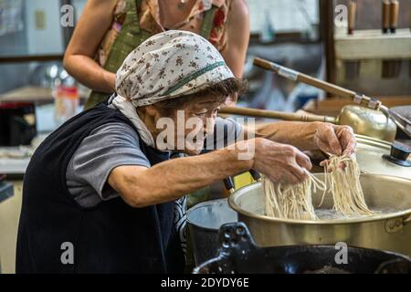 Soba Noodle Preparation a Fujinomiya, Giappone. Sumiko sano scorre le dita attraverso le sottili tagliatelle di soba. Non dovrebbero attaccarsi in nessun caso Foto Stock