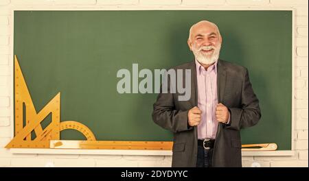 insegnante di uomo anziano usa gli attrezzi di matematica. l'uomo del docente bearded spiega la geometria sulla lavagna. torna a scuola. Strumenti grafici matematici. Lezione di trigonometria in classe. Scopri qui. Foto Stock