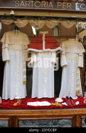 Il minuscolo e vecchio negozio 'Gammarelli' nel centro di Roma, in Italia, ha esposto il 4 marzo 2013 le tre serie di paramenti bianchi da spedire in Vaticano per il nuovo papa. Qui sono state realizzate tre versioni, piccole, medie e grandi dei paramenti bianchi che il nuovo papa indosserà quando apparirà per la prima volta al mondo. 'Gammarelli', come è conosciuta la casa di moda ecclesiastica, ha vestito i capi spirituali della Chiesa Cattolica Romana dal 1798. "Abbiamo preparato tre paramenti in lana bianca, una stola, loschi rossi, un cappuccio coprioggetto, nonché un capo in velluto rosso con bordo in pelliccia bianca, dal momento che è wi Foto Stock