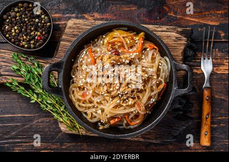 Tagliatelle di vetro di soia con funghi shiitake e carne di pollo. Sfondo di legno. Vista dall'alto Foto Stock