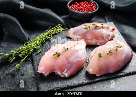 Filetto di coscia di pollo senza pelle. Sfondo nero. Vista dall'alto Foto Stock