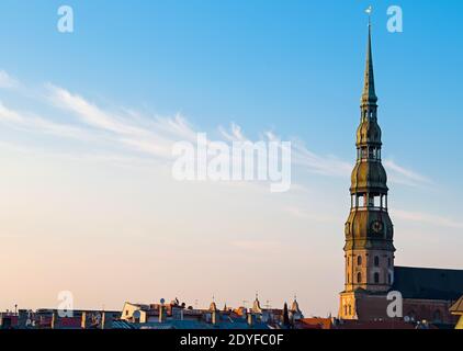 Simbolo di riga, vecchio orologio sulla torre medievale della chiesa di San Pietro tra tetti antichi edifici con architettura europea Foto Stock