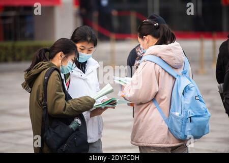 Changsha, la provincia di Hunan della Cina. 26 Dicembre 2020. Gli esaminatori hanno letto al di fuori di un sito d'esame presso la Central South University di Changsha, nella provincia di Hunan della Cina centrale, il 26 dicembre 2020. L'esame di ammissione post-laurea in Cina è iniziato sabato. Credit: Chen Sihan/Xinhua/Alamy Live News Foto Stock