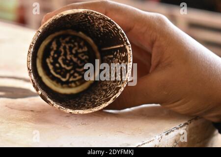 La mano di un uomo tiene una tazza di caffè vuota Foto Stock