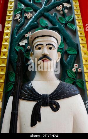 porta in legno intagliato, con guardia nel tempio buddista in thailandia Foto Stock