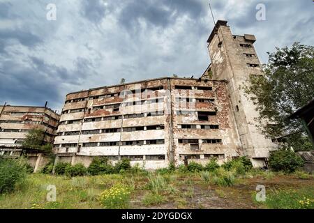 Vecchie mura abbandonate in cemento della fabbrica senza finestre Foto Stock