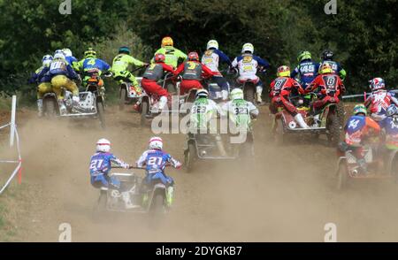 grande gruppo di abiti da moto-cross alla stella di una gara con polvere e sporcizia che volano ovunque Foto Stock