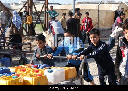 Baghdad. 26 Dicembre 2020. I bambini ricevono la distribuzione di carburante nel campo U3 di Hasansham nella provincia di Ninive, Iraq, 8 dicembre 2020. La pandemia COVID-19 in corso ha aumentato i livelli di vulnerabilità degli sfollati interni in Iraq. Le agenzie di aiuto non possono fare tanto per aiutare, e contenere il virus contagioso nei campi sta diventando sempre più difficile. Credit: Xinhua/Alamy Live News Foto Stock