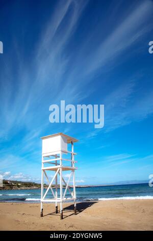 Una torre di bagnino si erge vuota all'inizio della stagione primaverile presso la spiaggia di Kalathas, vicino alla Canea, Creta. Foto Stock