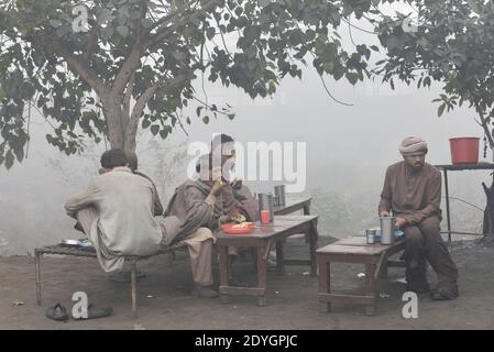 I pendolari pakistani fanno il loro senso fra la nebbia densa su un Inverno freddo a Lahore Foto Stock