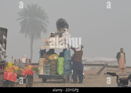 I pendolari pakistani fanno il loro senso fra la nebbia densa su un Inverno freddo a Lahore Foto Stock