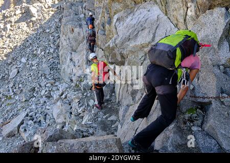 Amici, ragazzi e ragazze, fare un trekking sulle rocce di montagna e la natura. Foto Stock