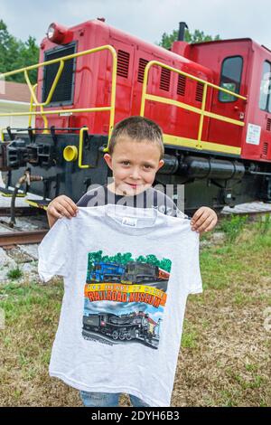 Alabama Calera Heart of Dixie Railroad Museum, bambino ragazzo bambino visitatore caboose treno che tiene souvenir maglietta, Foto Stock