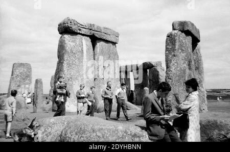 Anni '50, visitatori storici, al famoso monumento antico di Stonehenge, Wiltshire, Inghilterra, Regno Unito, un anello preistorico di pietre in piedi stimato essere stato costruito tra il 3000 e il 2000 AC. Si pensa che la zona fosse originariamente un antico terreno di sepoltura. In quest'epoca i visitatori potevano camminare liberamente tra le pietre, ma le preoccupazioni per l'erosione hanno visto che questo è arrivato a una fine nel 1977, quando l'accesso a loro è stato roped via. Foto Stock