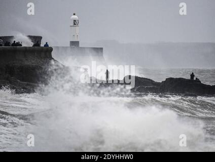 Porthcawl, Galles, 26 dicembre 2020 la gente guarda come Storm Bella colpisce Porthcawl durante l'alta marea a Porthcawl, la sera del Santo Stefano mentre pioggia e forti venti colpiscono parti del Regno Unito. Foto Stock