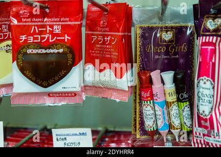 Confezioni di forniture per la cottura e la decorazione di dolci sono appese a uno scaffale di un supermercato a Nishiizu-Cho, Prefettura di Shizuoka, Giappone: piastre di cioccolato a forma di cuore, dragées argentate commestibili e penne decorative al cioccolato colorate della gamma Deco Girls. Foto Stock