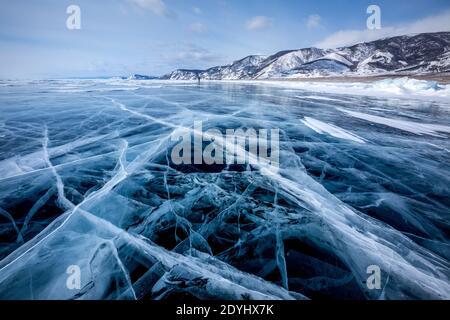 Vista della bella disegni su ghiaccio da crepe e bolle di gas in profondità sulla superficie del lago Baikal in inverno, Russia Foto Stock