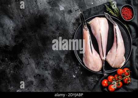 Separa pesce crudo pescano. Sfondo nero. Vista dall'alto. Spazio di copia Foto Stock