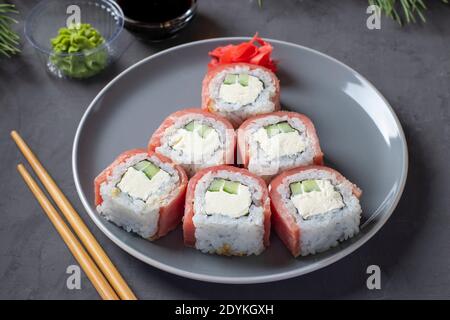 Albero di natale commestibile fatto di sushi di tonno con formaggio philadelphia su piatto grigio. Primo piano. Festa di Capodanno. Foto Stock