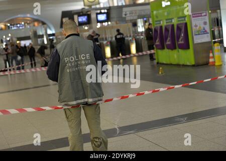 Gli ufficiali forensi cercano le prove nella scena in cui un soldato è stato pugnalato a Parigi, Francia, 25 maggio 2013. La polizia francese sta cacciando un uomo che ha attaccato un soldato in pattuglia con due colleghi nel quartiere commerciale la Defense di Parigi sabato sera. Il privato Cedric Cordier di prima classe è stato avvicinato da dietro e pugnalato nel collo con un coltello a pale piccole. Il ministro della Difesa Jean Yves le Drian ha detto ai giornalisti che era stato designato a causa della sua professione. Ma il presidente Francois Hollande ha rifiutato di stabilire un legame diretto con l'assassinio di un soldato a Londra mercoledì. Phot Foto Stock