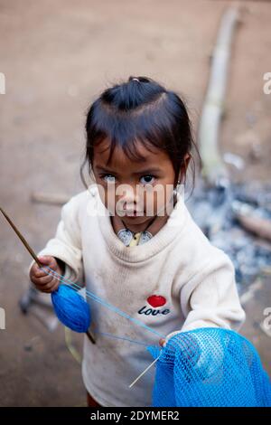 Luang Namtha, Laos - 2019 novembre: Bambina laotiana di etnia khmu cucire un cesto nel villaggio locale Foto Stock