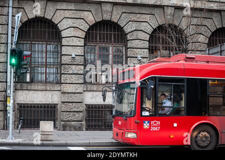 BELGRADO, SERBIA - 29 NOVEMBRE 2020: Autista del trolley bus un uomo, che lavora nella sua cabina indossando una maschera respiratoria nel trasporto pubblico a Belg Foto Stock