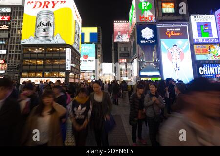 Pannelli illuminati di notte sull'affollato Ponte Ebissubashi sul canale Dotonbori. Foto Stock