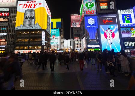 Pannelli illuminati di notte sull'affollato Ponte Ebissubashi sul canale Dotonbori. Foto Stock