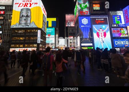 Pannelli illuminati di notte sull'affollato Ponte Ebissubashi sul canale Dotonbori. Foto Stock