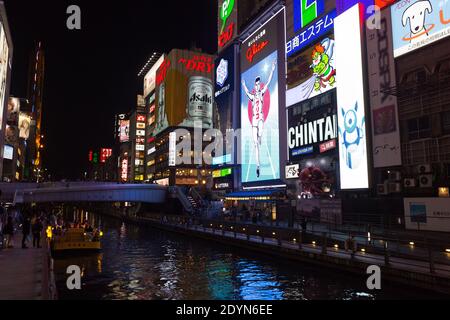 Pannelli illuminati di notte sull'affollato Ponte Ebissubashi sul canale Dotonbori. Foto Stock