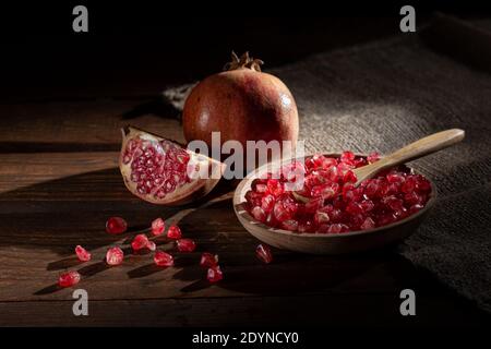 Semi di melograno e melograno su piastra di legno su base di legno Foto Stock