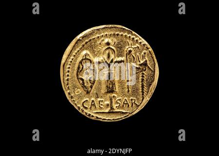 Lato opposto di una replica romana Aureus Gold Coin di Julius Cesare con un Trofeo di armi galliche colpito tra 48-47 BC tagliato e isolato su un blac Foto Stock