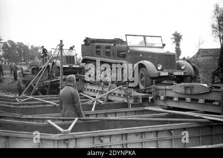 Wehrmacht Heer Brückenpioniere Brückenbau mit SD.Kfz 7 Halbkettenfahrzeug Mittlerer Zugkraftwagen 8 t - Ponte dell'Esercito Tedesco Pioneers con mezzo-pista militare Veicolo SD.Kfz 7 8 t. Foto Stock