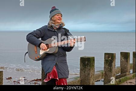 Portobello, Edimburgo, Scozia, Regno Unito. 27 dicembre 2020. Rosie Nimmo agghiacciandosi sui groynes al mare durante questi tempi difficili di Covid -19 Lockdown trova la spiaggia dà la sua ispirazione e la aiuta a rilassarsi. Rosie è una cantante/cantautrice di Edimburgo che si esibisce anche in una band jazz/blues. Il suo nuovo album, Where Time Suspends, è finito e in attesa di essere rilasciato il 5 febbraio 2021. I suoi primi tre album, Lazy and Mellow, Home e Scrapbook, sono andati a raccogliere molte recensioni illuminanti e ad essere suonati da diversi programmi radiofonici, tra cui Iain Anderson Credit: Arch White/ della BBC radio Scotland Foto Stock