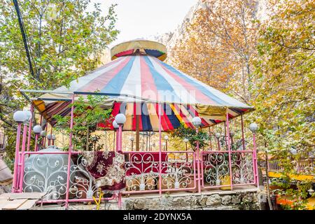 Ristoranti iraniani con grande ombrello all'ingresso della valle del Darband del monte Tochal. Una popolare regione ricreativa per gli abitanti di Teheran Foto Stock