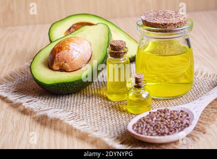 Olio di avocado e avocado su fondo di legno. Messa a fuoco selettiva Foto Stock