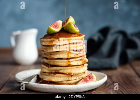 Frittelle soffici al latticello con fichi e sciroppo. Delizioso e appetitoso stack di frittelle dense Foto Stock