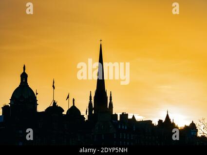 Silhouette di edifici nello skyline della città al tramonto con un cielo arancione tramonto, Edimburgo, Scozia, Regno Unito Foto Stock