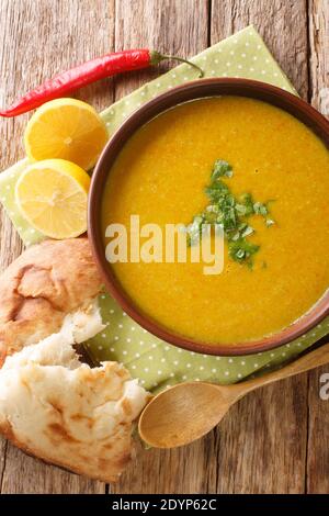 Zuppa libanese di lenticchie Shorbat Adas primo piano nella ciotola sul tavolo. Vista dall'alto verticale Foto Stock