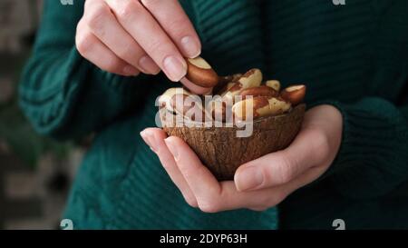 Brasile noci in mani femminili. Noci sane ricche di proteine Foto Stock