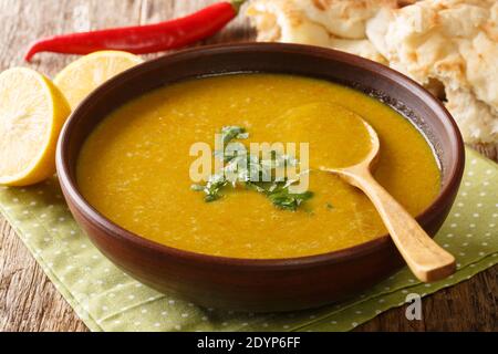 Zuppa di purea di lenticchie mediorientali di Shorbat Adas nella ciotola sul tavolo. Orizzontale Foto Stock