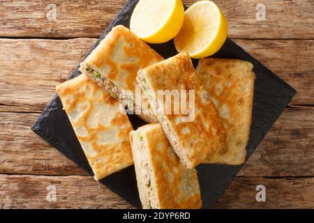 Mutabbaq è un pane arabo con uova e carne piccante che riempiono il primo piano sul tavolo. Vista dall'alto orizzontale Foto Stock