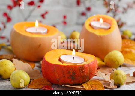 Disposizione autunnale di piccole zucche intagliate per contenere candele luminose per un'esposizione decorativa del giardino. REGNO UNITO Foto Stock