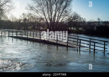 Oxford, Oxfordshire, Regno Unito. 27 dicembre 2020. Il ponte pedonale lungo il Tamigi è allagato. Inondazioni nell'Oxfordshire. Storm Bella ha portato ancora più pioggia a Oxford causando inondazioni in zone basse. Molta gente è fuori esercitarsi nel sole. Credit: Sidney Bruere/Alamy Live News Foto Stock
