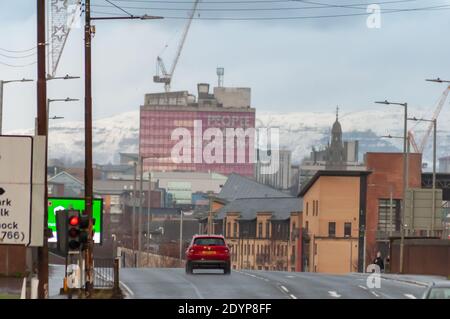 Glasgow, Scozia, Regno Unito. 27 Dicembre 2020. Regno Unito Meteo: Paesaggio urbano con colline innevate sullo sfondo. Credito: SKULLY/Alamy Live News Foto Stock