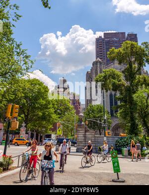 Central Park a New York City in una giornata estiva brillante. Numerosi pedoni e ciclisti sono visti nel colpo. Foto Stock