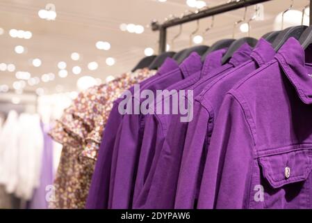 Abbigliamento donna - collezione autunno inverno. Giacche in denim su appendiabiti in negozio. Il concetto di consumo cosciente e riciclaggio delle cose. Foto Stock
