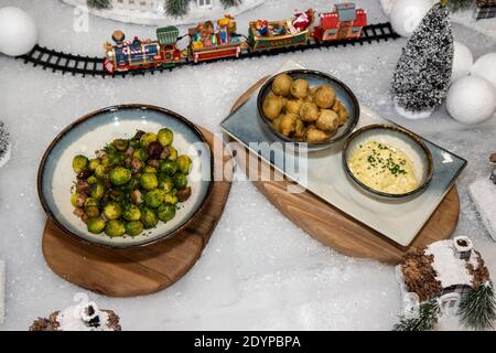 Un delizioso piatto di cavoletti di Bruxelles cotti e fritti Uno sfondo a tema natalizio Foto Stock